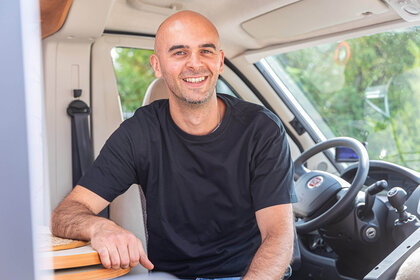 SMV Mitarbeiter Antonio Murolo sitzt lächelnd auf dem Beifahrersitz in einem Wohnmobil.