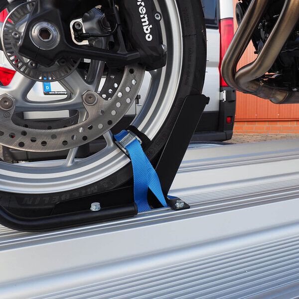 SMV Alu-Star Rolli. Das Vorderrad eines Motorrades mit Spanngurt auf der Plattform gesichert.